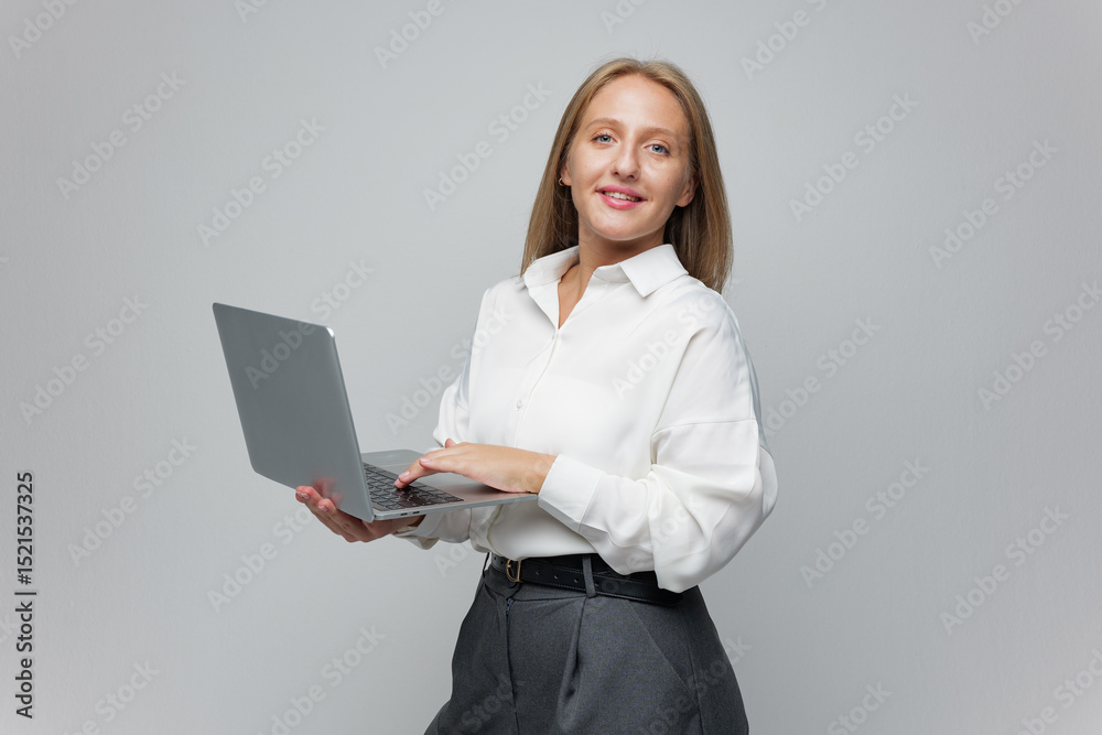 Confident Woman Holds Laptop and Smiles, Showcasing Technology and Professionalism in a Modern Workspace Environment Confident Woman Holds Laptop and Smiles, Showcasing Technology and Professionalism in a Modern Workspace Environment