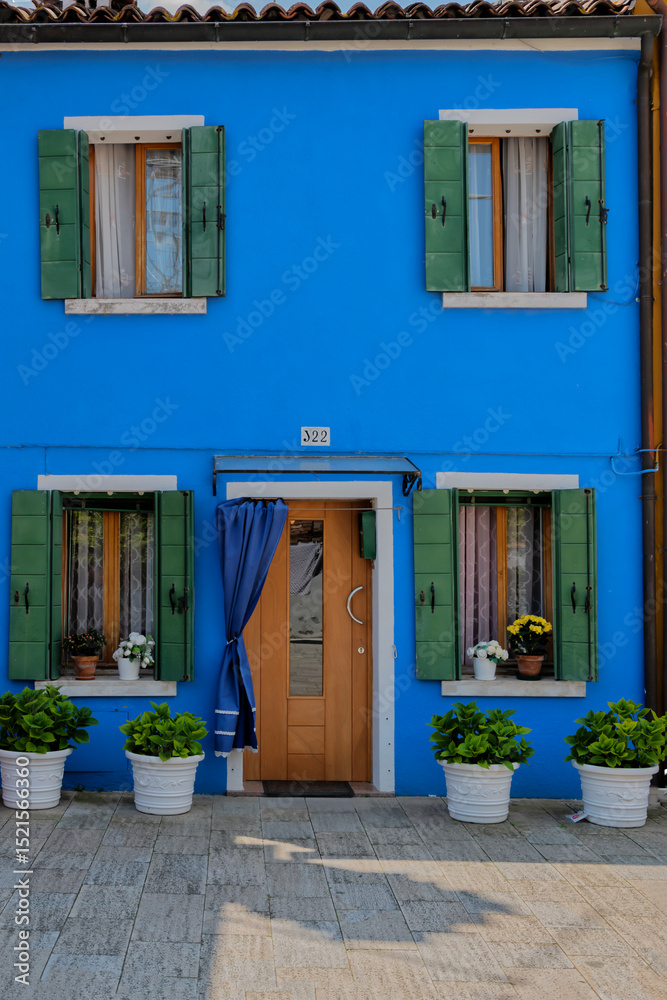Fototapeta premium Blue house with green shutters. Burano island, Venice