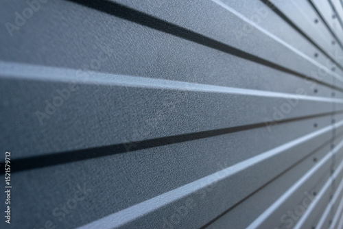 The texture of the garage or fence, the roof, the sandwich panel of gray color is close-up.