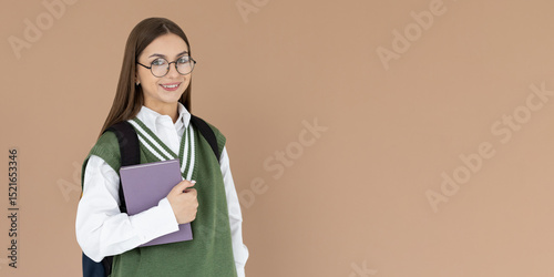Caucasian girl student in green vest with backpack, folder, books, notebook, notepad in hands with glasses smiling isolated on white studio background, copy space