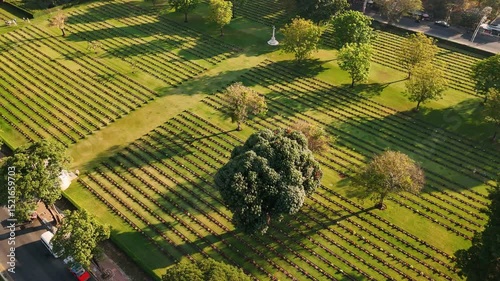 War cemetery near kanchanaburi displaying symmetrically arranged tombstones, commemorating fallen soldiers among verdant grounds in historic memorial site, Thailand. 