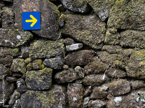 yellow arrow pointing into the direction of the pilgrimiage in portugal on the camino de Santiago, the road to santiago, christian pilgrimage