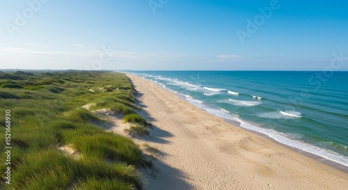 Coastal Dunes and Ocean Waves - Scenic aerial view of a pristine beach with rolling sand dunes and turquoise ocean waves under a clear blue sky
