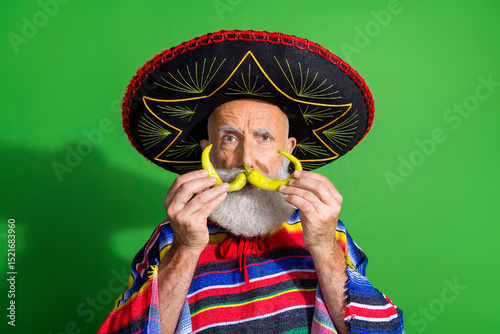 Wall Mural Charismatic man in traditional colorful Mexican attire posing with playful gestu