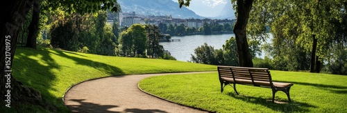 Scenic Pathway Along a Tranquil Lake Surrounded by Green Trees in Summer.