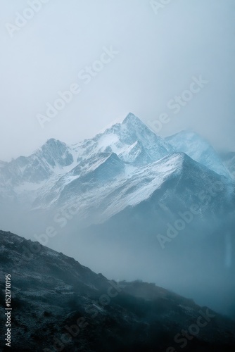 Majestic Snow-Capped Mountains Rise Above Misty Valleys in Early Morning Light.