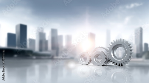 Gears placed on a reflective surface with a modern city skyline in the background during daylight hours