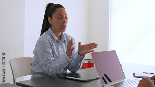 Businesswoman discussing project with male colleague in office meeting