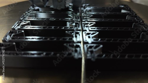 3 d printer makes prints parts from black plastic material,3D printer in operation close-up. Automatic three dimensional 3d printing performs plastic modeling in laboratory. The 4ht industrial