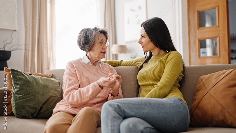 Fotografie Two Caucasian people hugging each other while sitting on sofa