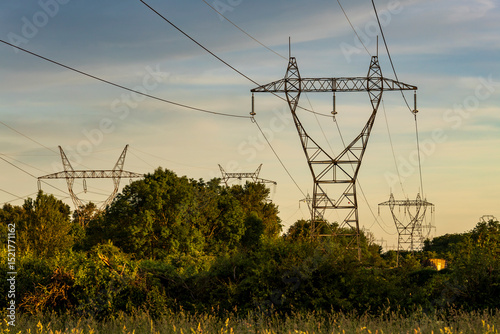 High voltage pylon in the French countryside at sunset. 400 kV High voltage electric power grid.
