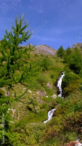 Hidden alpine waterfall on rocky slope in Bionaz mountains