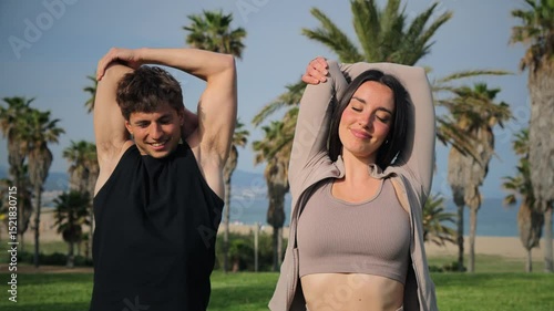A fit couple demonstrates their strength and fitness by flexing their impressive muscles with joy and enthusiasm. Their playful attitude highlights the joy of fitness and healthy living.