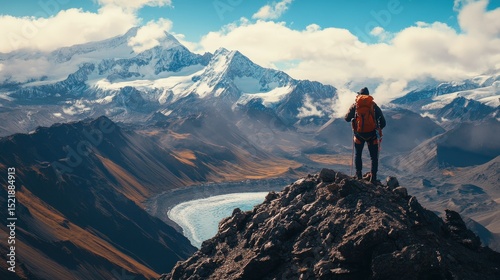 Summit Vista: A lone hiker stands triumphantly atop a rocky peak, gazing out over a breathtaking alpine panorama. The rugged mountain terrain and vast sky create a scene of adventure and achievement.
