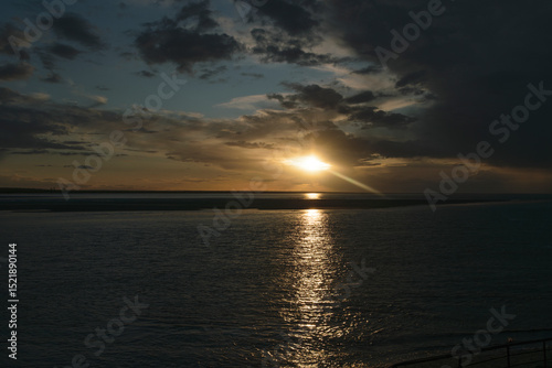 Sunset over the tranquil ocean reflecting warm colors at the horizon during twilight