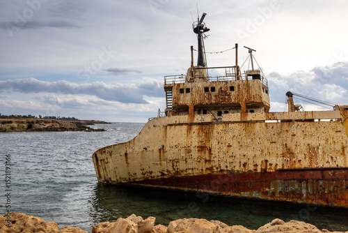 Old rust ship wreck on a rocky coast  in Mediterranean sea at Akrotiri Beach in Cyprus. Shipwreck of the abandoned ship