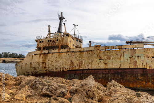 Old rust ship wreck on a rocky coast  in Mediterranean sea at Akrotiri Beach in Cyprus. Shipwreck of the abandoned ship