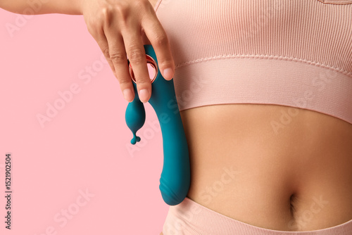 Beautiful young woman in sexy underwear with vibrator on pink background, closeup