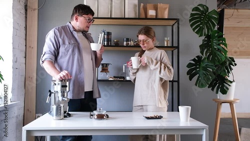 young millennial couple tasting coffee at home , making coffee in the morning