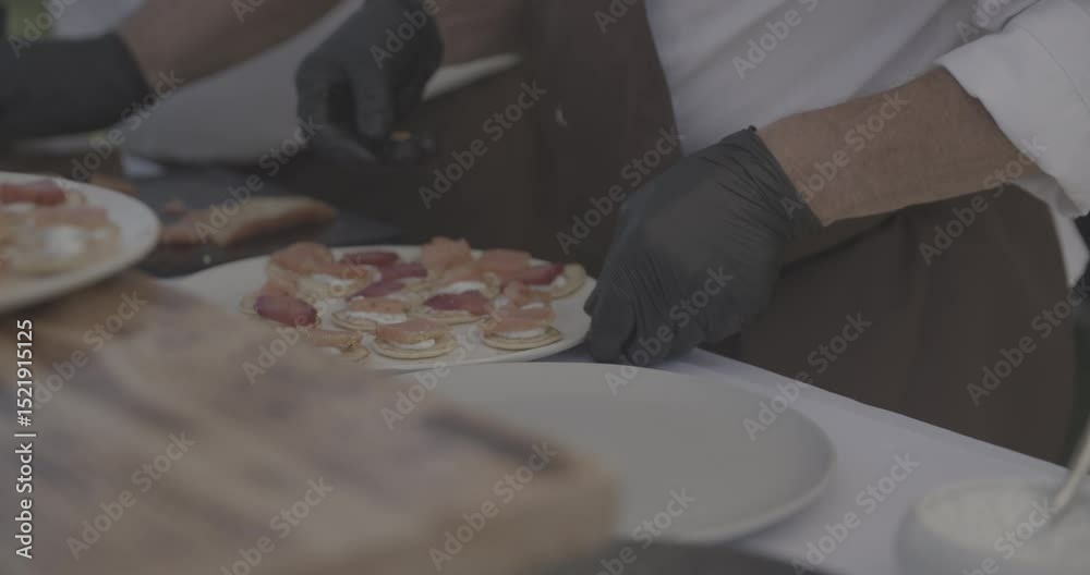 Cuisiniers présentants des amuse-bouches à base de viande sur des tablettes en bois devant eux