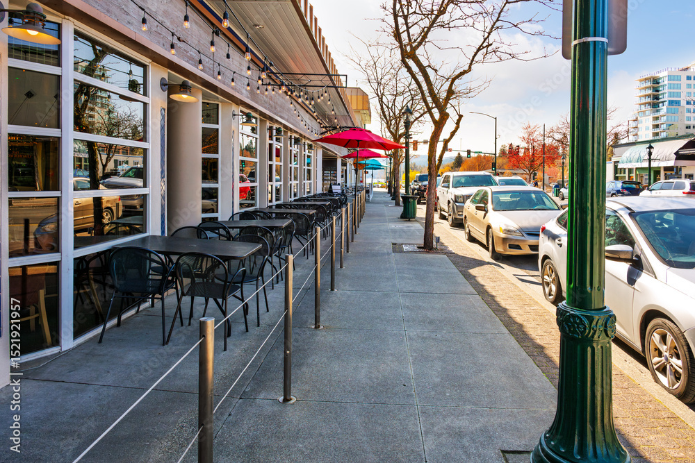 Fototapeta premium Rows of sidewalk cafes along Sherman Avenue with the lake in the distance in downtown Coeur d'Alene, Idaho.