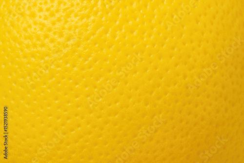 Yellow lemon peel macro showing bright color and detailed bumpy texture of citrus skin

