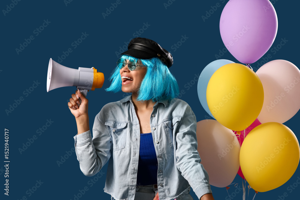 Naklejka premium Stylish young African-American woman in wig shouting into megaphone and balloons on blue background