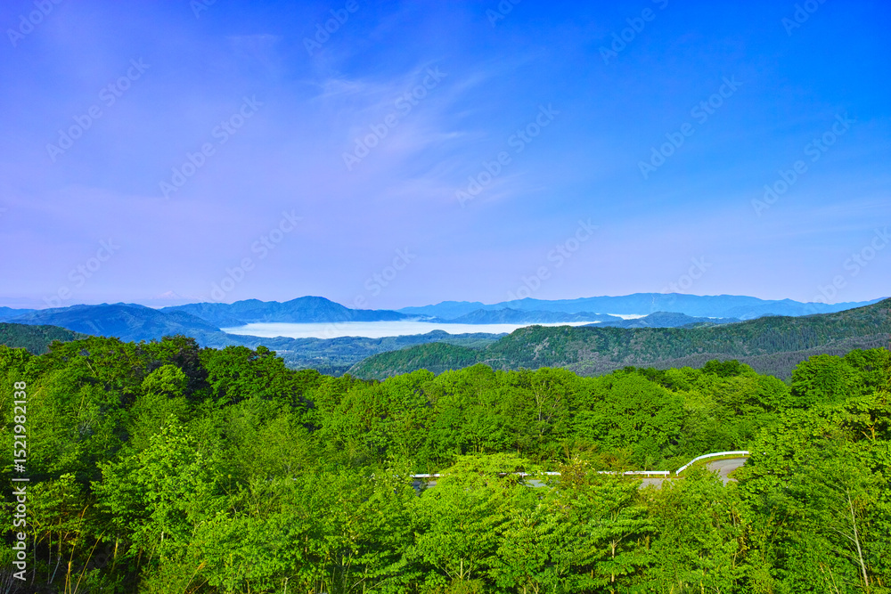 Obraz premium 新緑の秋田県仙北市にある田沢湖の遠望、早朝の幻想的な雲海を抱く田沢湖 