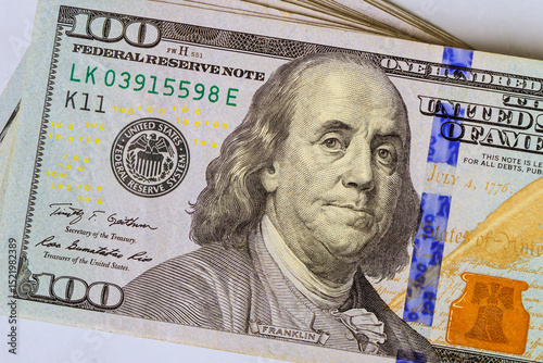American hundred dollar bill highlighting Benjamin Franklin elements of currency design.