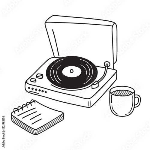A turntable placed near a tea cup and notebook