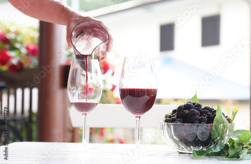 Pouring mulberry juice into glass.
