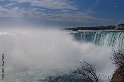 A dramatic view of Niagara Falls’ Horseshoe Falls, with turquoise water plunging into a misty abyss.