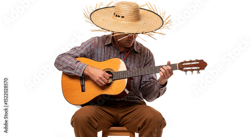 Man playing acoustic guitar in traditional straw hat, seated on wooden stool, against a white backdrop