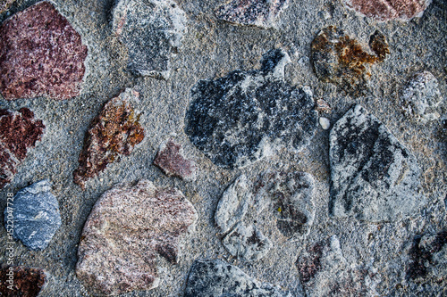 Close-up view of a rough cobblestone wall with varied textures and colors.