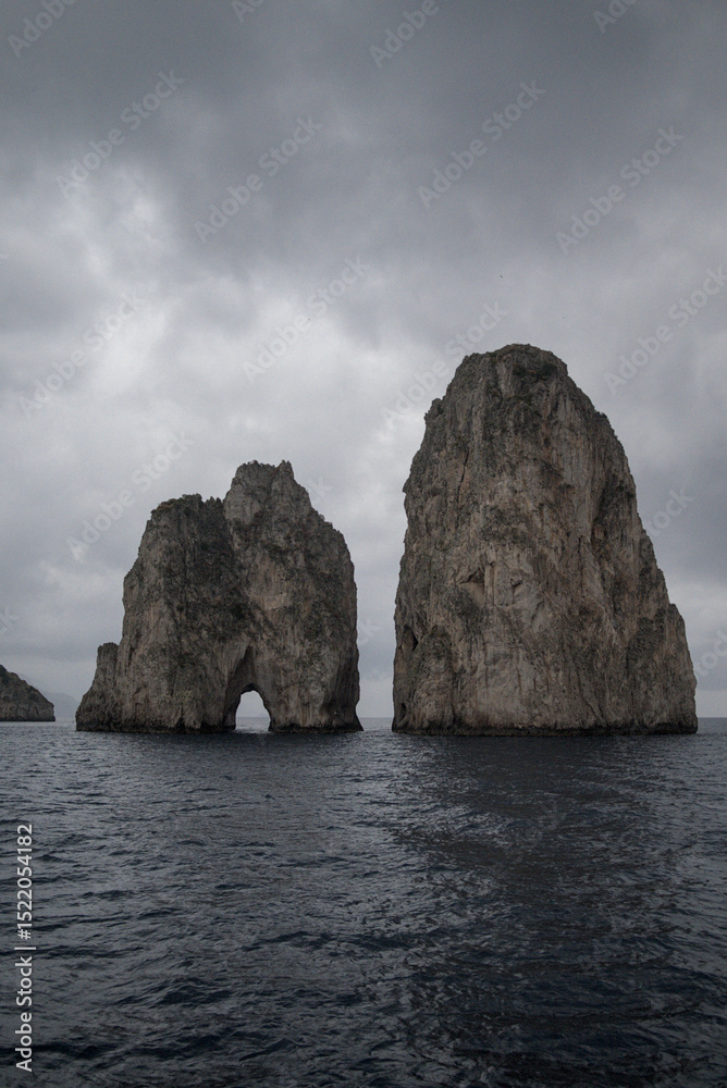 Naklejka premium Majestic Faraglioni Rocks of Capri Under a Dramatic Sky