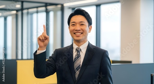 Asian business man pointing up with idea in office setting professional headshot for corporate website