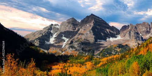Panoramic view of scenic Maroon bells mountains in autumn time with cloudy dramatic sky.