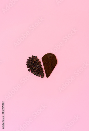 Forma de corazón aislada hecha con granos de café tostado y café tostado molido, sobre fondo rosado