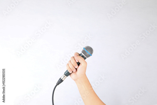 Hand holding microphone on white background.