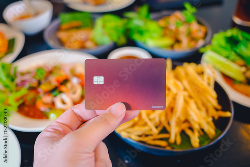 Diners at a Thai restaurant readily present their credit cards, a clear illustration of how these cards offer global acceptance, unparalleled convenience, and attractive discounts. photo