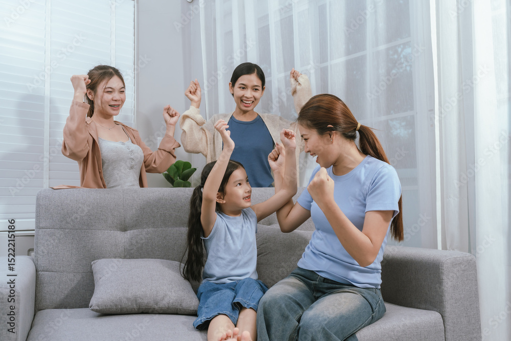 Obraz premium Happy Asian family sitting on cozy living room sofa, bonding and smiling while enjoying time together with children in a warm home.