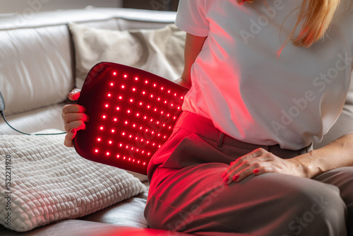 Infrared light therapy belt on the back reduces pain and inflammation from strain or injury. It boosts blood flow and aids tissue healing, enhancing mobility and comfort with non invasive treatment. photo