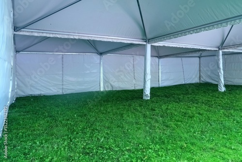White tent set up on grass.