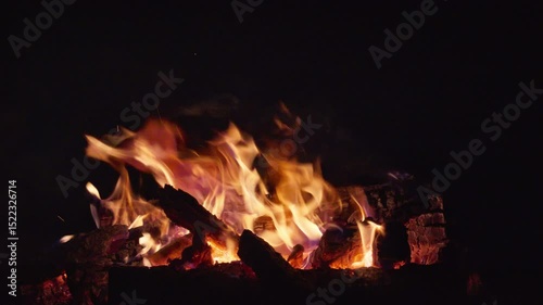 A large bonfire at night with crackling wood. Video with sound.