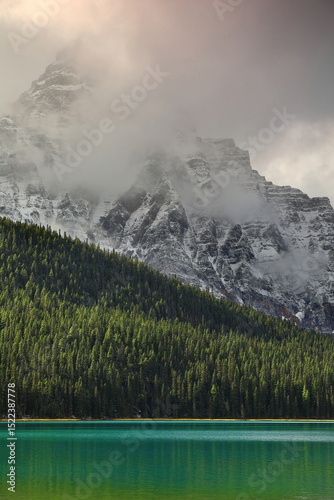 Emerald-green Lower Waterfowl Lake at the misty Waputik Range foot, the 3266 m high Mount Chephren rising on its SW shore. Banff NP-Alberta-Canada-329