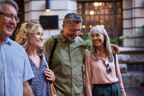 фотографія Smiling mature friends walking together outdoors
