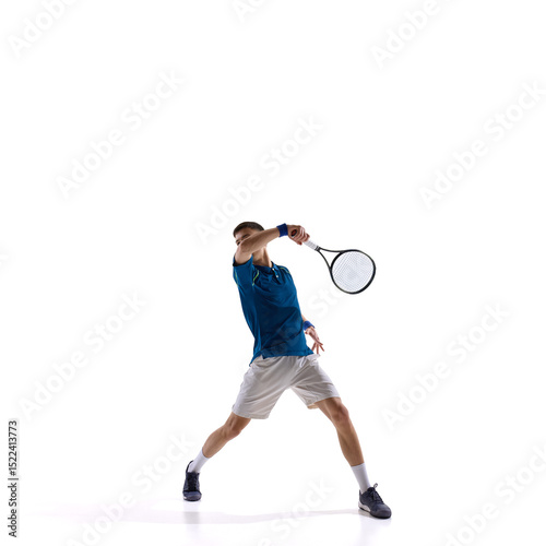 Tennis player stretching low to return fast ball, full body lunge with arm extended against white studio background. Concept of sport, speed response, critical match point, victorious point