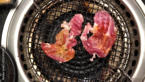 Meat slides are gilling on electric stove in bbq Korean restaurant 