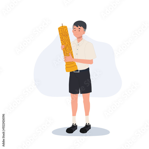 thai schoolboy holding large wax candle for buddhist holiday celebration in thailand cultural festival and asian tradition.