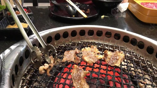 Meat slides are gilling on electric stove in bbq Korean restaurant 